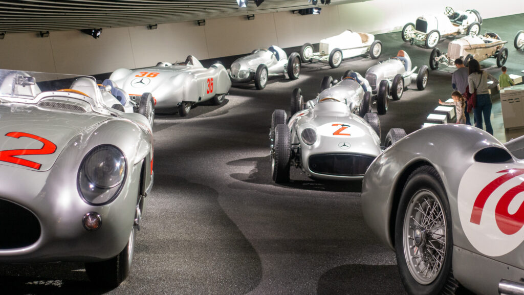 Historische Rennwägen auf einer Rennbahn im Mercedes-Benz Museum in Stuttgart.